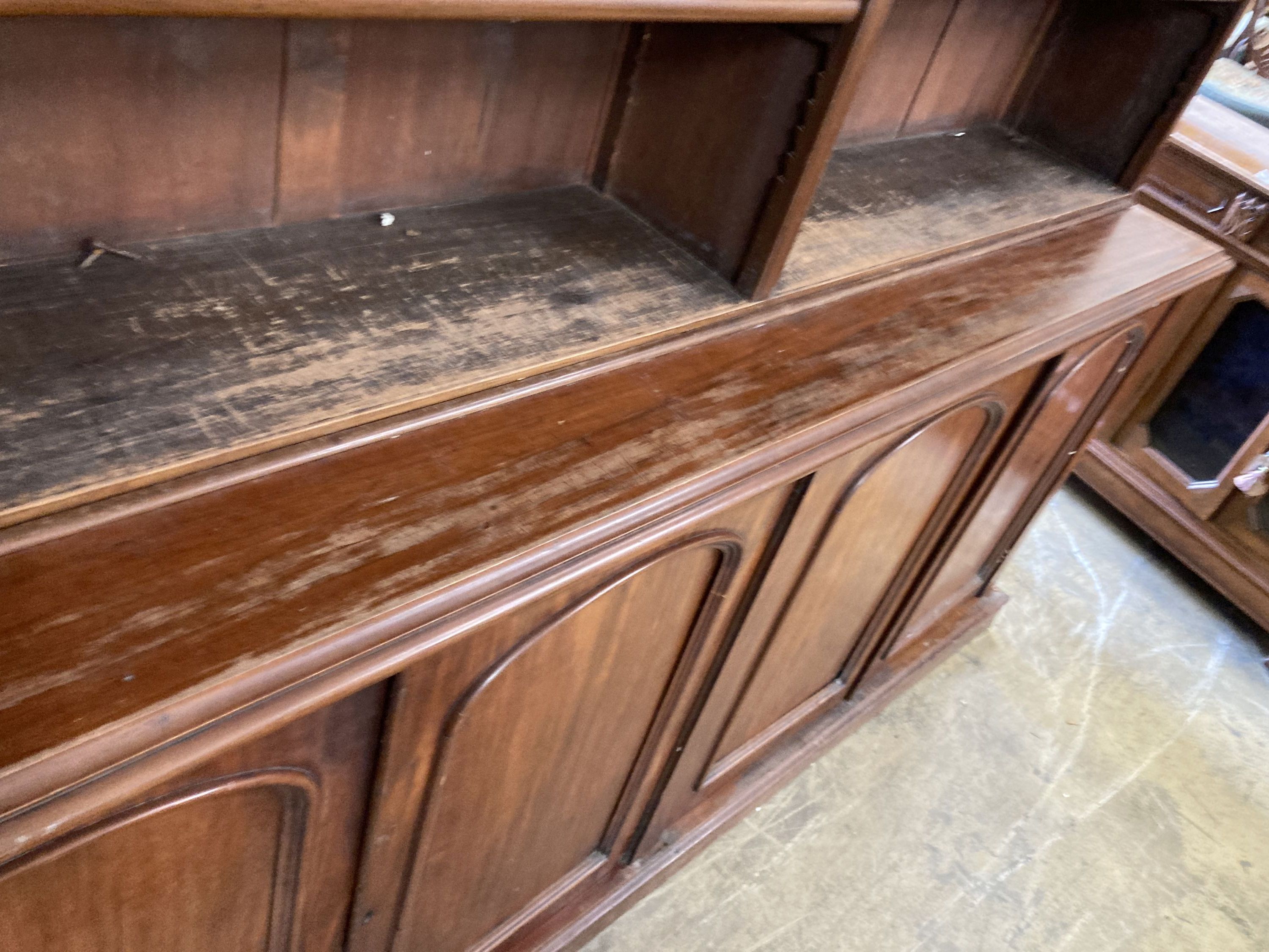 A Victorian mahogany library bookcase, the open shelves over an enclosed four door base, length 230cm, depth 50cm, height 238cm